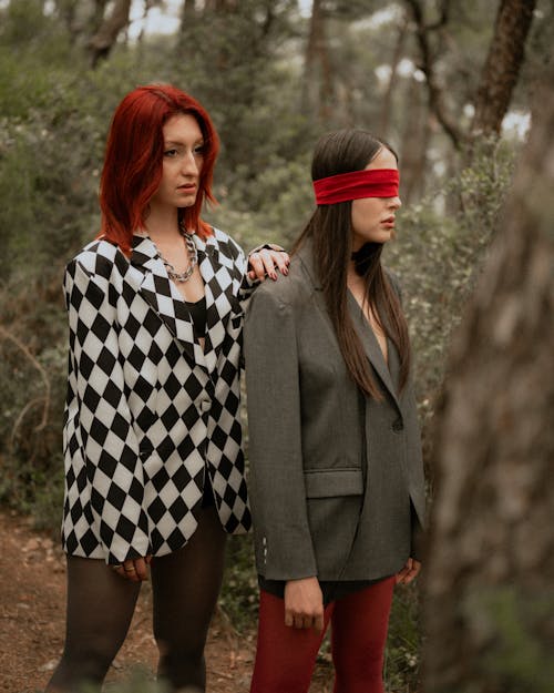 Two women in checkered outfits standing in the woods