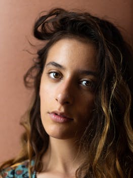 一位黑发卷发女子的特写肖像，眼神温柔凝视