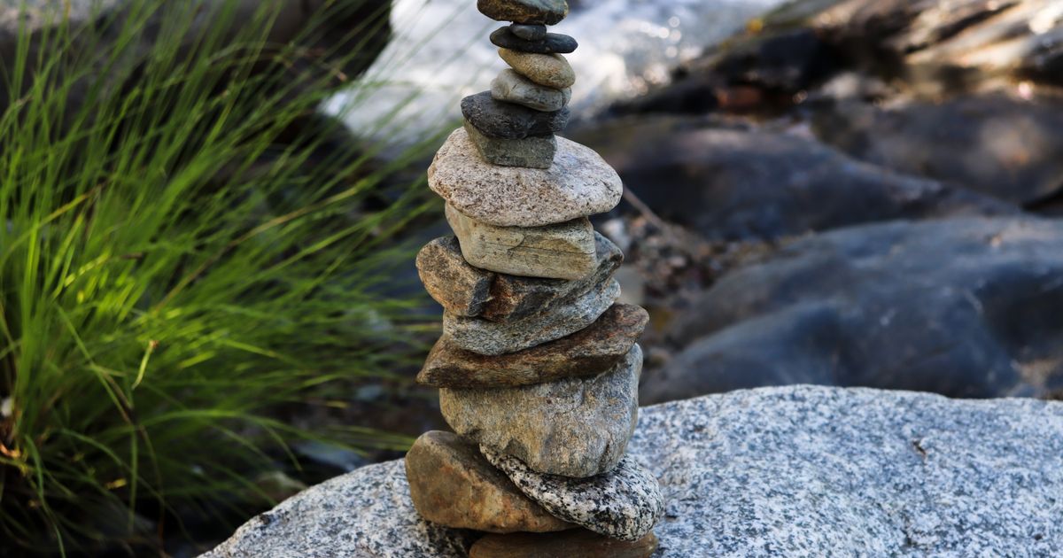 A small tower of balanced stones near a river, representing a balanced price range (BPR)