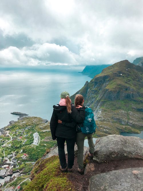 Photo of Two Women Standing on Cliff 
