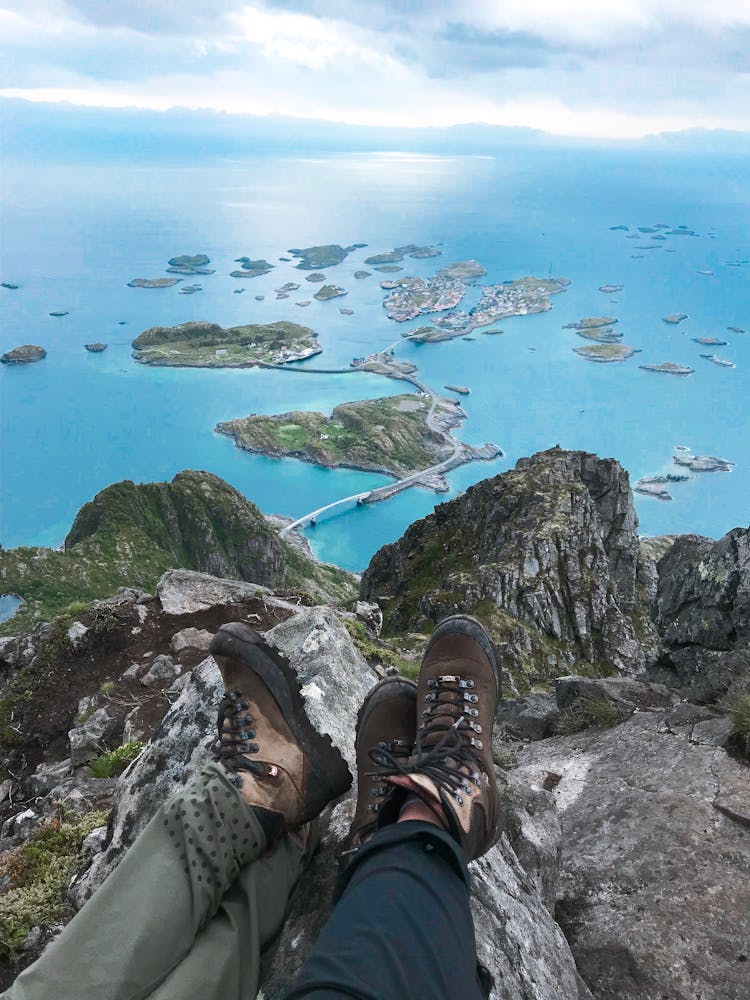 Two People Sitting Near Cliff