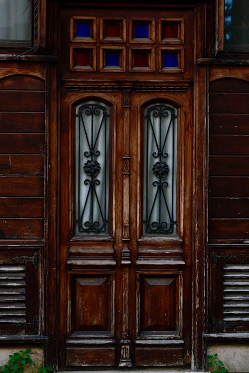 A wooden door with glass panels and a decorative door