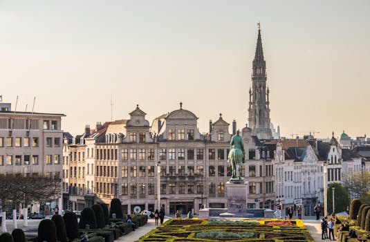 A beautiful cityscape of Brussels with the iconic Town Hall tower and vibrant gardens. by Petar Starčević