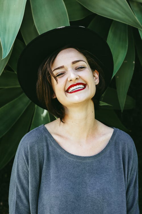 Free Photo of a Smiling Woman Wearing Gray Top and Black Hat Stock Photo