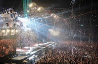 音乐会现场充满活力，灯光闪烁，五彩纸屑飘扬，人群热情洋溢