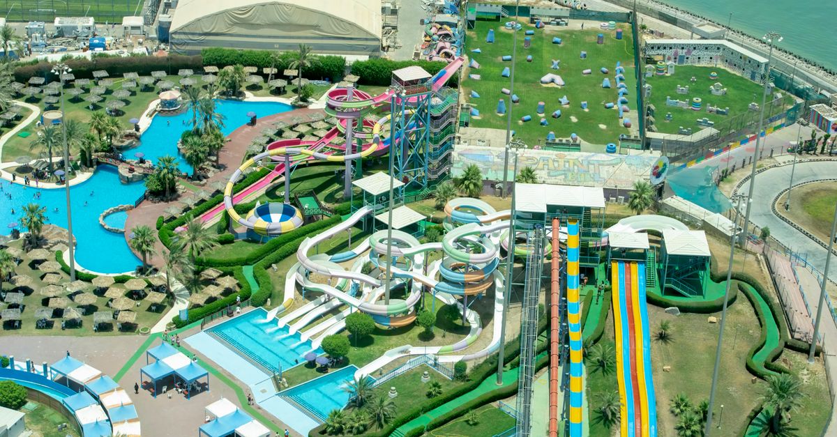 Capture the excitement of a vibrant water park from above, showcasing colorful slides and pools.