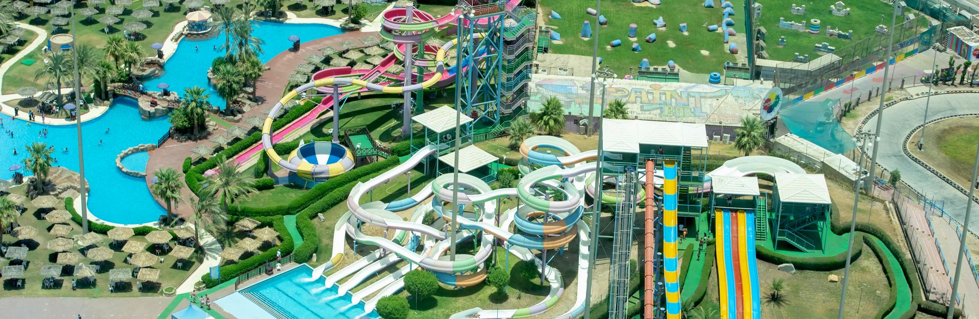 Capture the excitement of a vibrant water park from above, showcasing colorful slides and pools.