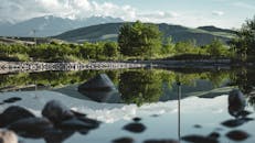 湖面宁静的景色映衬着郁郁葱葱的绿树和远处的山脉