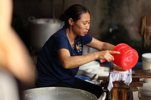 Free Senior woman preparing food in a kitchen using a traditional method, focused in a close-up setting. Stock Photo