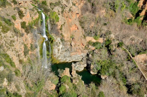 An aerial view of a waterfall in the middle of a forest