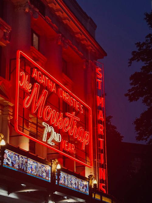 Free Illuminated St Martin's Theatre displaying Agatha Christie's 'The Mousetrap' neon sign in London nightscape. Stock Photo