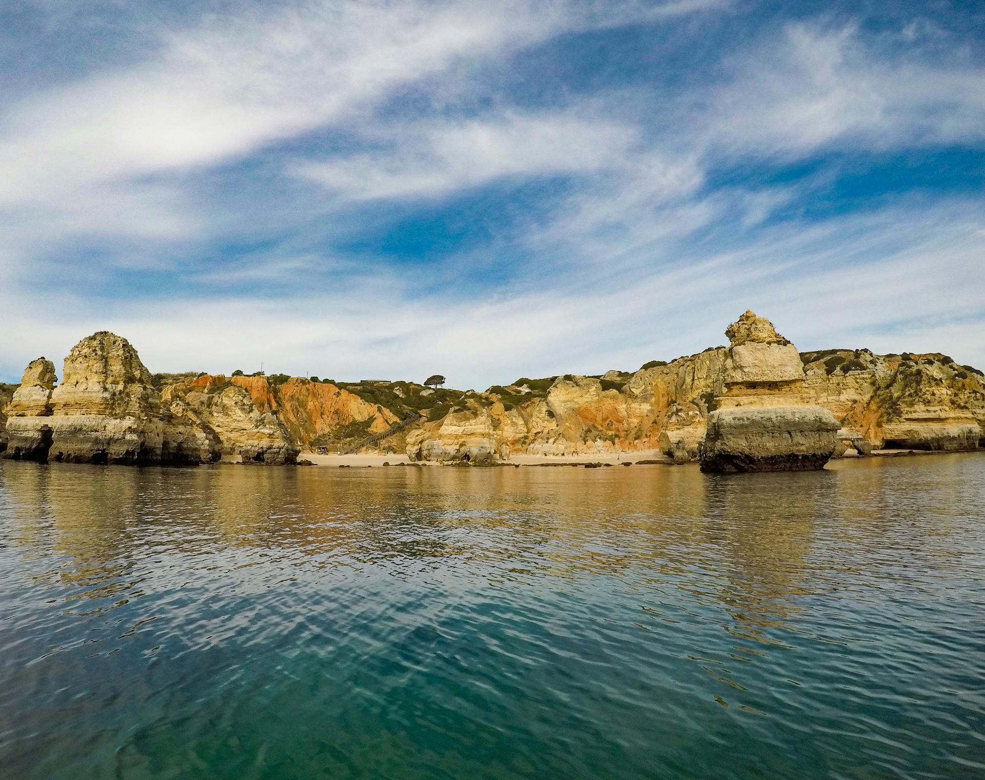 Beautiful rock formations along the Algarve coast, Portugal under a cloudy sky.