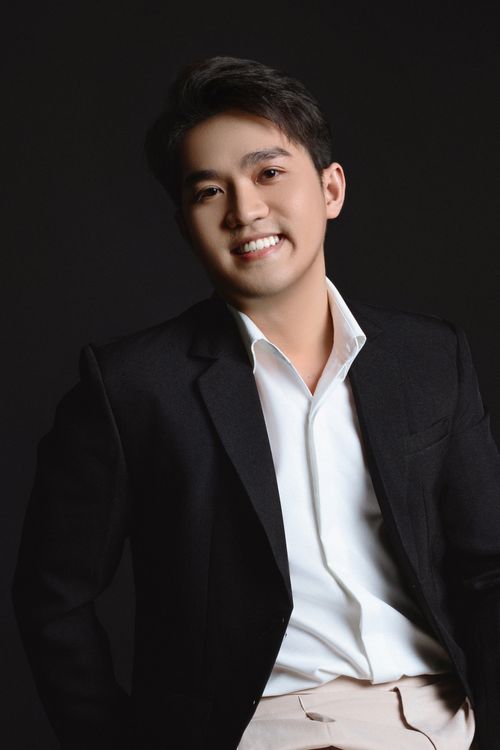 Free Fashionable young man smiling in a studio portrait, exuding confidence and style. Stock Photo