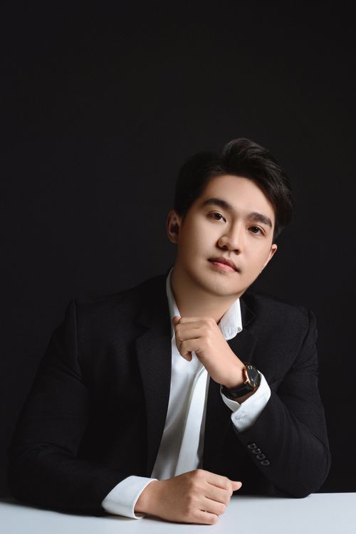 Free Portrait of a confident Asian man in formal attire against a black backdrop, emphasizing elegance and style. Stock Photo