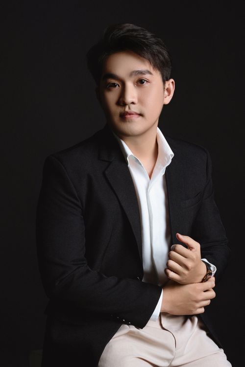 Free Studio portrait of an Asian man in a black suit on a dark background, showcasing elegance and style. Stock Photo