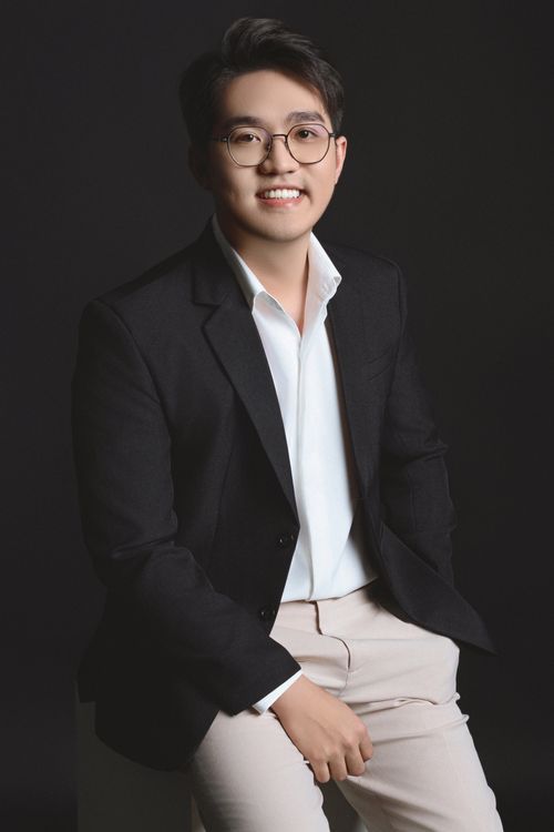 Free Elegant portrait of a smiling man wearing a black blazer and glasses in a studio setting. Stock Photo