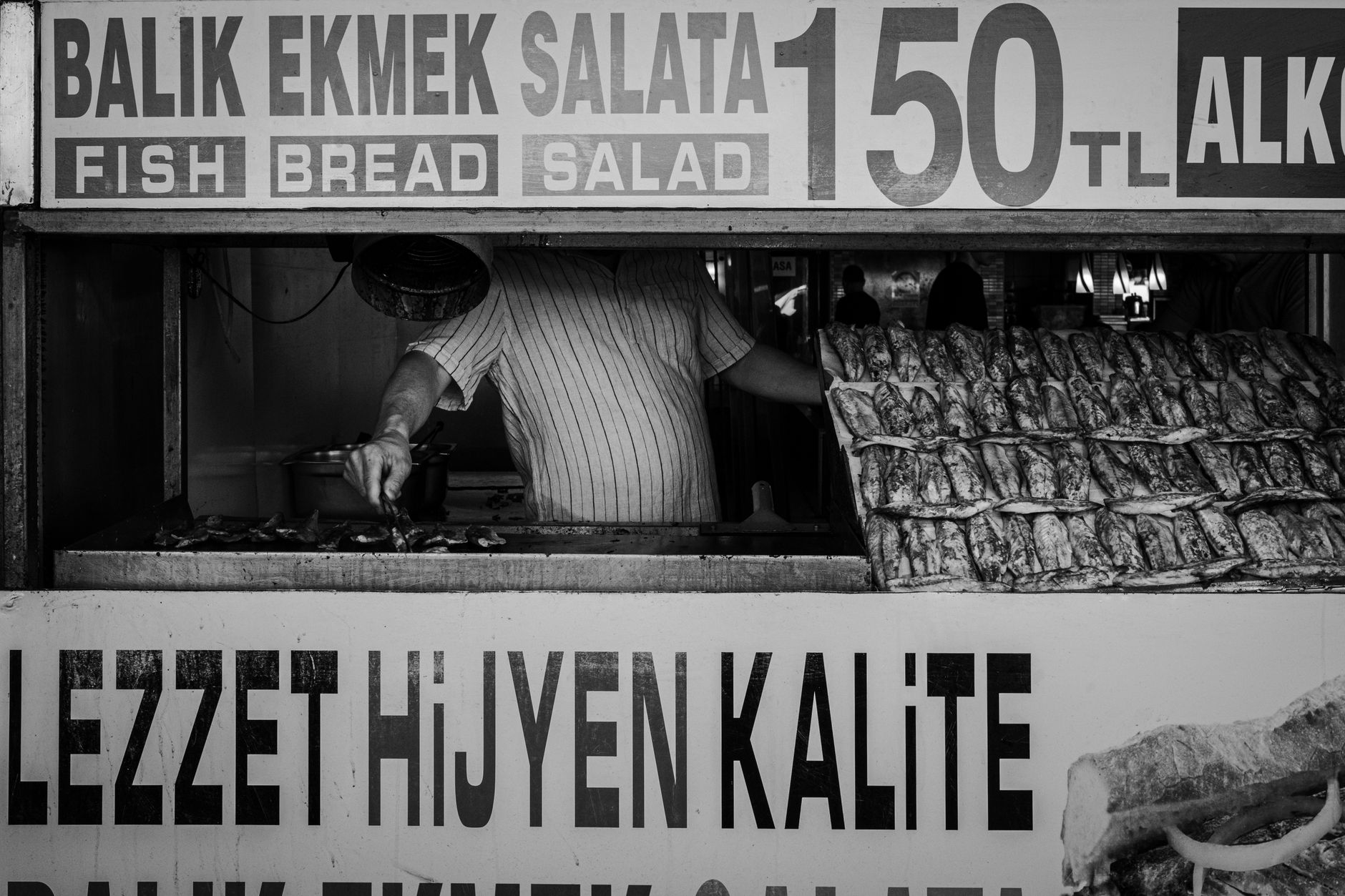 A man prepares balik ekmek at a traditional street food stand in Istanbul, Turkey.