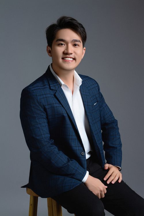 Free Studio portrait of a smiling man dressed in a suit, set against a gray background, exuding confidence and style. Stock Photo