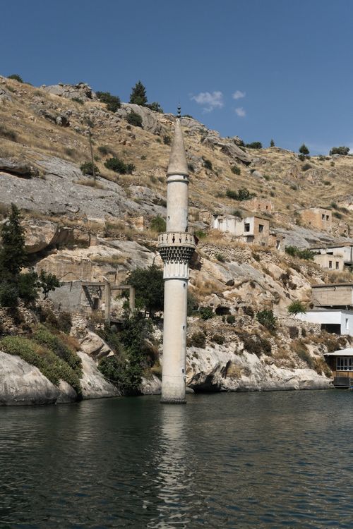 Free Discover the unique charm of a submerged minaret in Halfeti, Turkey, against rocky terrain and serene waters. Stock Photo