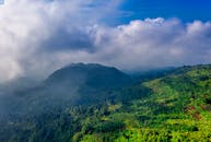 在多云天空的映衬下，一幅壮丽的鸟瞰图展现了印度尼西亚万丹郁郁葱葱的绿色山脉