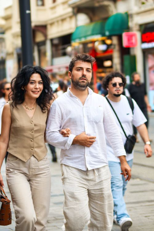 Free A fashionable couple strolls through a vibrant city street, showcasing modern urban lifestyle. Stock Photo