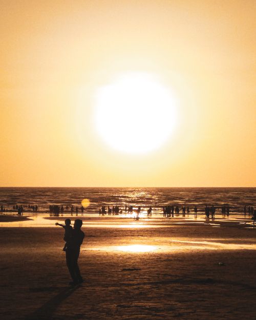 Free A captivating sunset view at Juhu Beach, Mumbai, with silhouettes of people against the golden horizon. Stock Photo