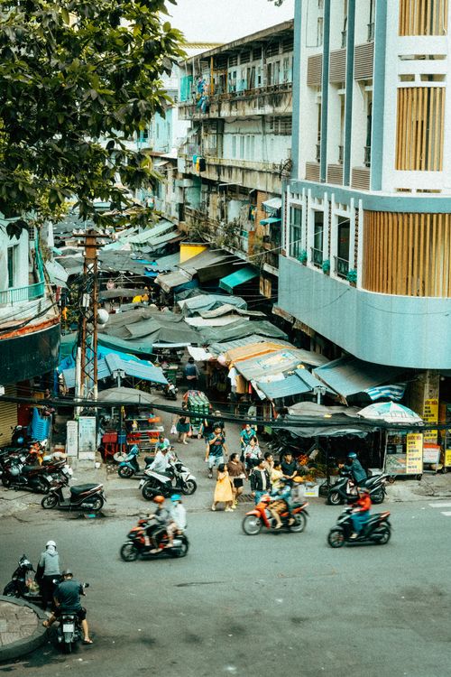 Free Vibrant and busy street scene in Ho Chi Minh City's local market with people and mopeds. Stock Photo