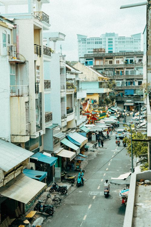 Free A vibrant market street scene in Ho Chi Minh City with busy shops and mopeds. Stock Photo