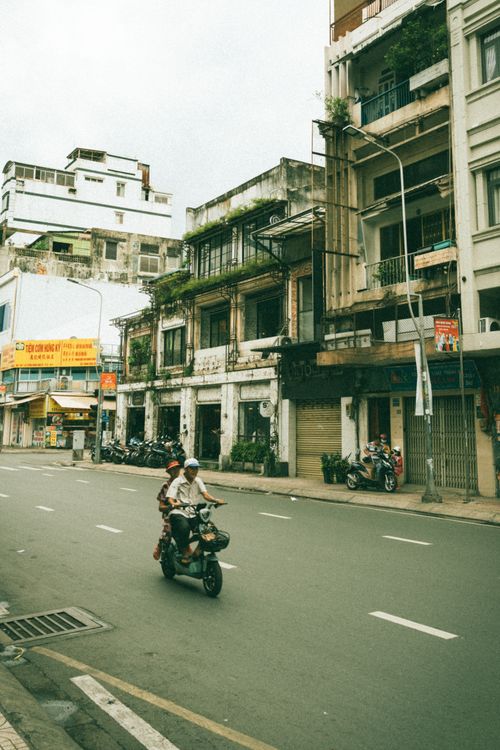 Free Two people riding a motor scooter through the streets of Ho Chi Minh City, Vietnam. Stock Photo