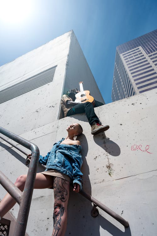 Woman in Blue Denim Jacket and Beige Skirt Standing on Stairs