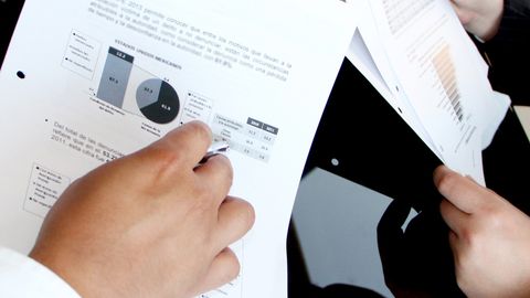 A business team reviewing charts and graphs on documents, emphasizing data analysis and teamwork.