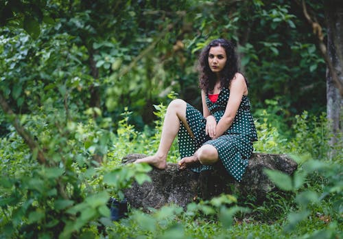 Woman Sitting on Rock in Forest
