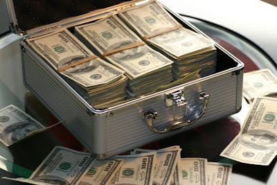 piles of money in an opened safe