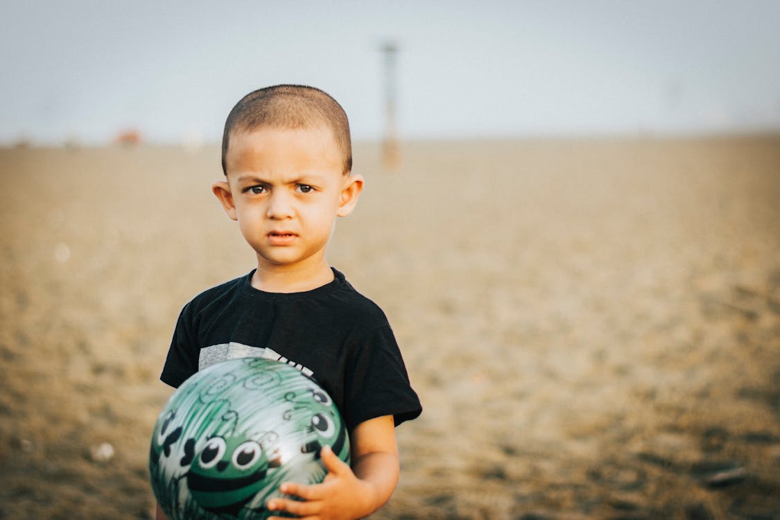 Free Close-Up Photo of Boy Holding A Ball Stock Photo