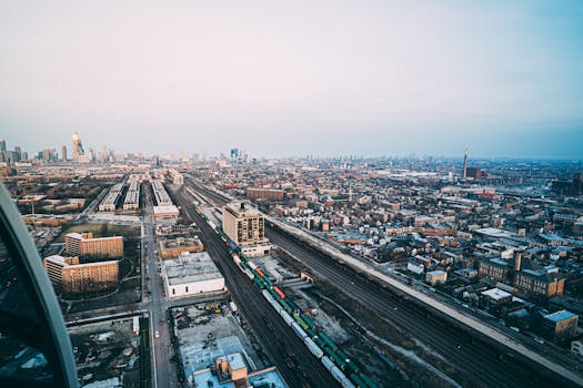 从空中俯瞰，繁华的城市景观中，道路和摩天大楼沐浴在日光下