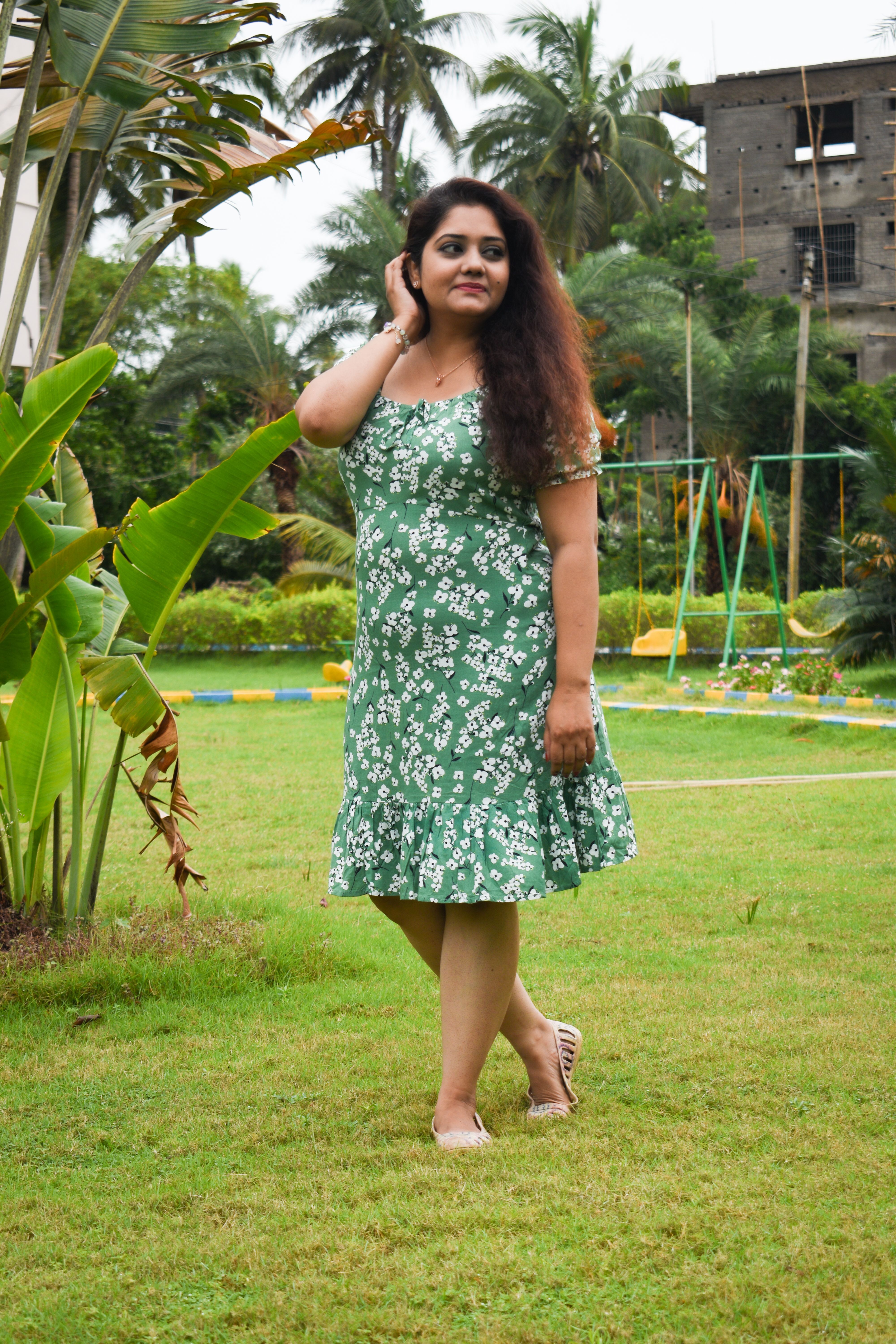 A woman in a green dress standing in a park · Free Stock Photo