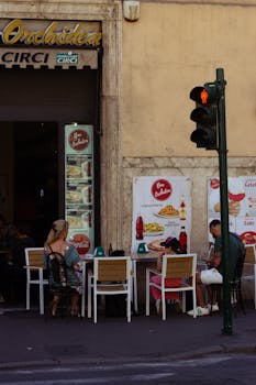People enjoying a street cafe in Lazio, Italy, showcasing urban dining culture.
