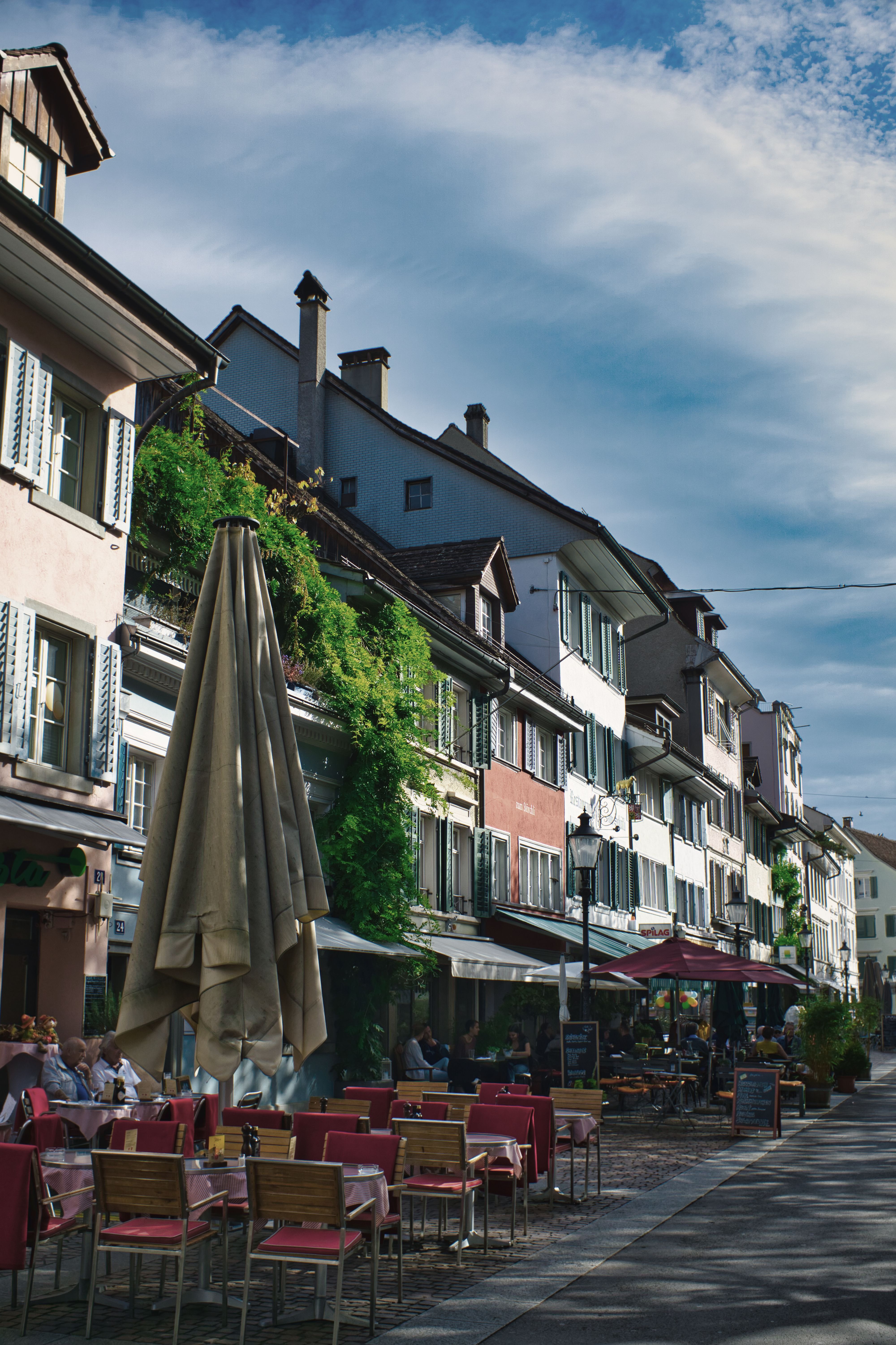 Charming street with outdoor dining in Winterthur, Switzerland, capturing European architecture and urban life.