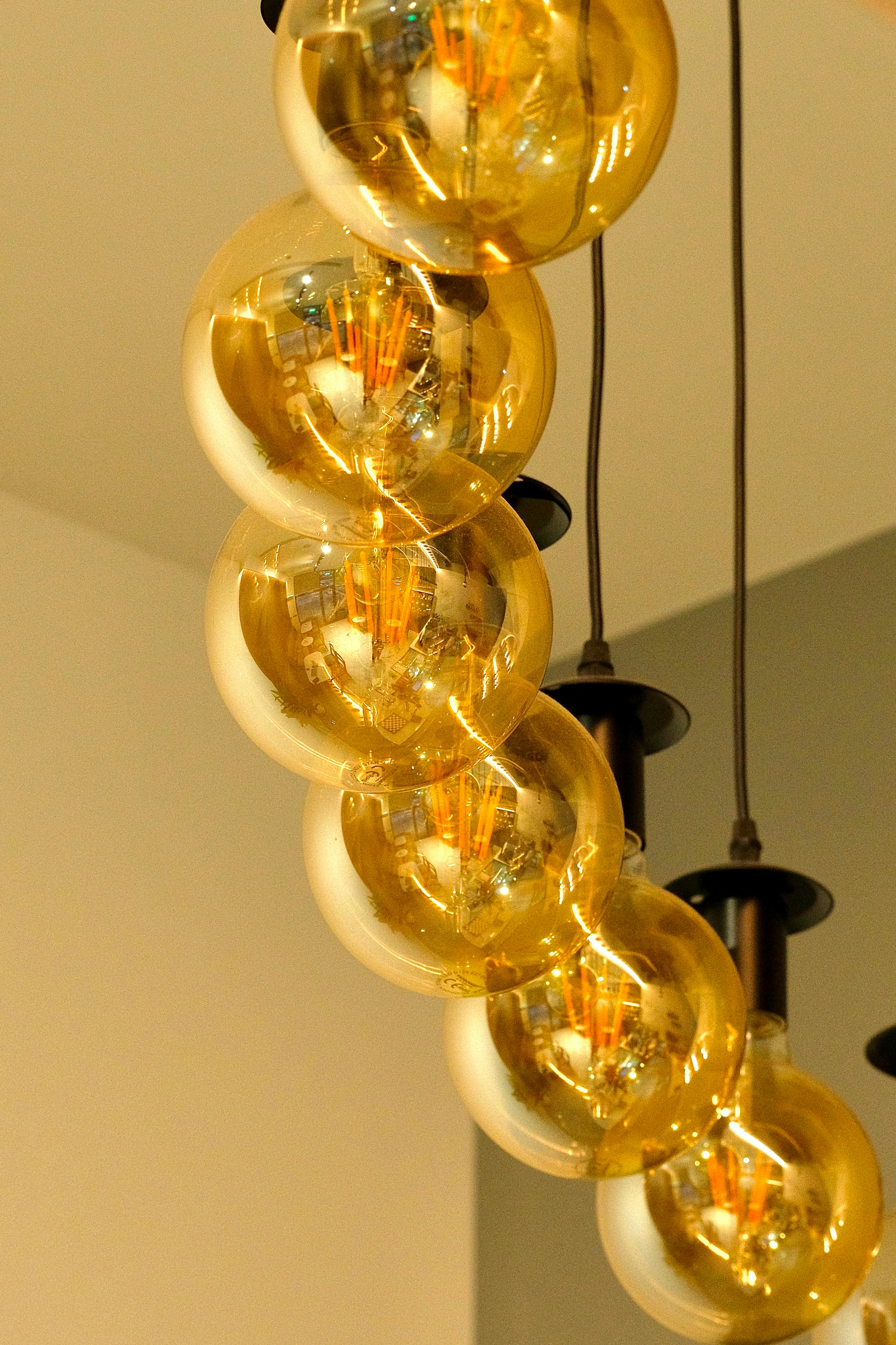 Close-up of modern pendant lights with golden glass bulbs, perfect for stylish interiors.
