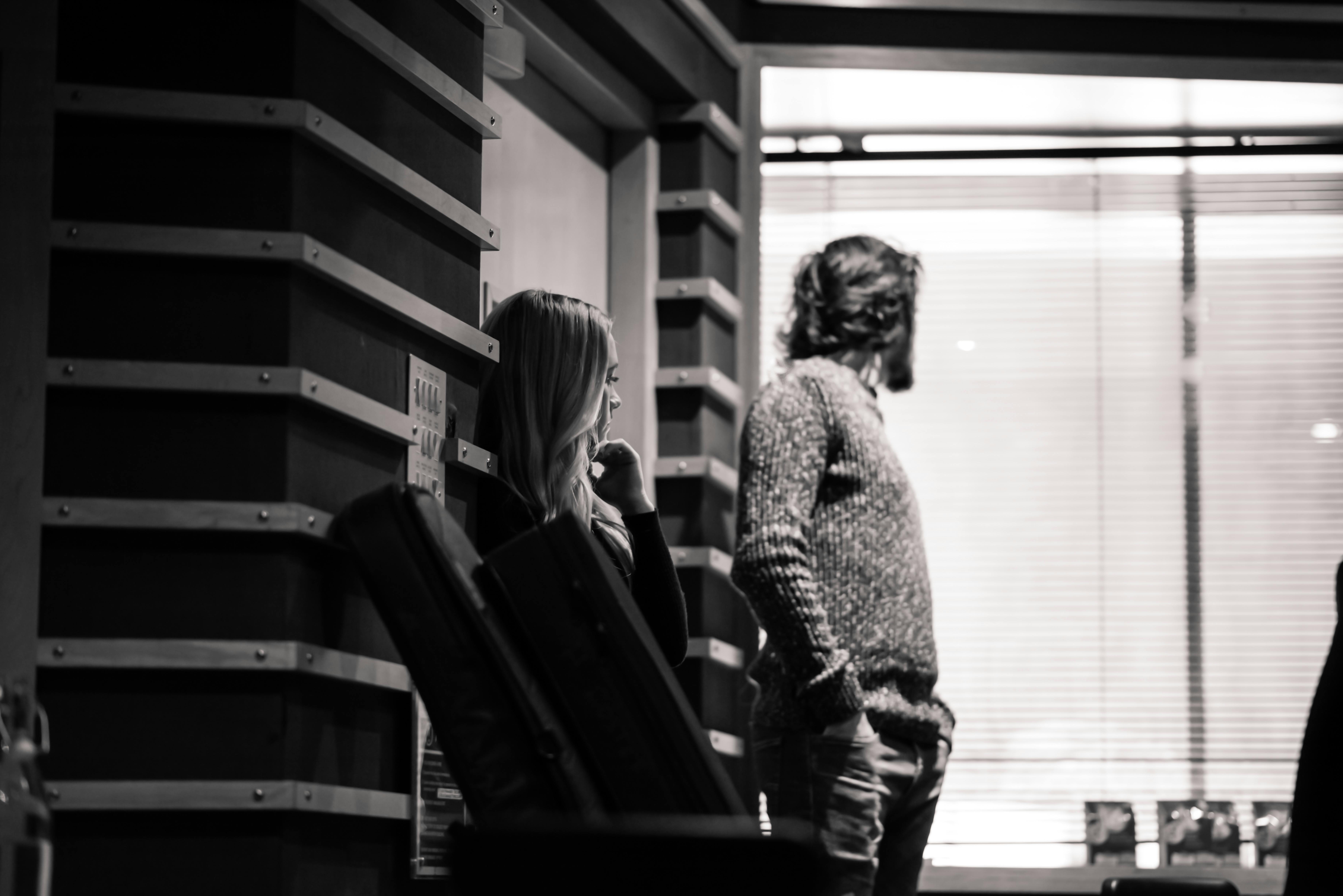 a man and woman standing in front of a window