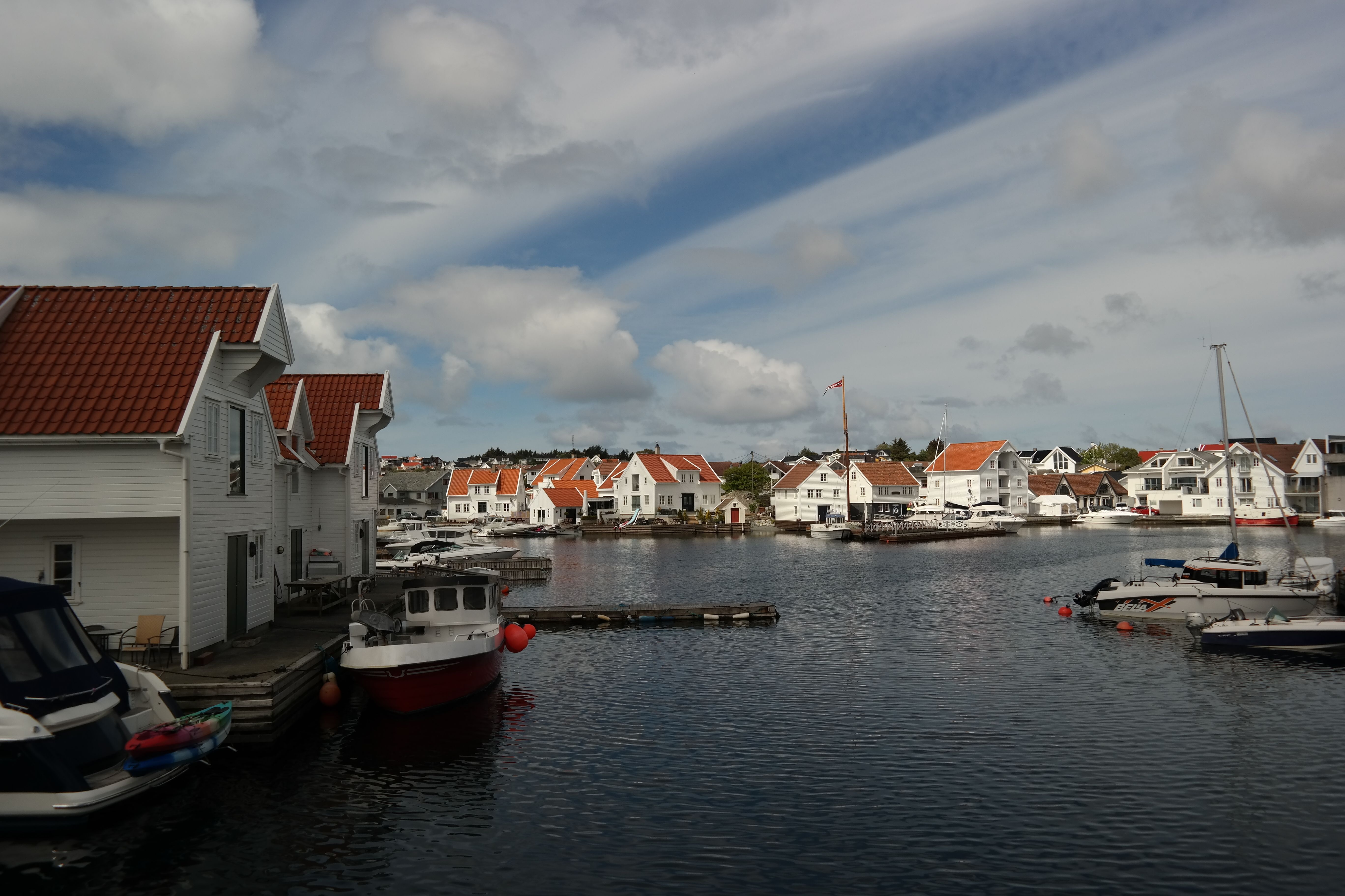 Picturesque view of Skudeneshavn's iconic waterfront with white houses and moored boats.