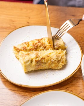 Appetizing omelette served on a plate, captured in a bright setting.