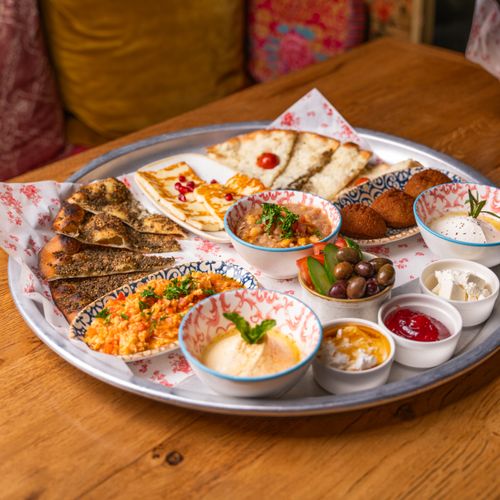 Free Colorful Mediterranean mezze platter featuring hummus, olives, and a variety of fresh appetizers. Stock Photo