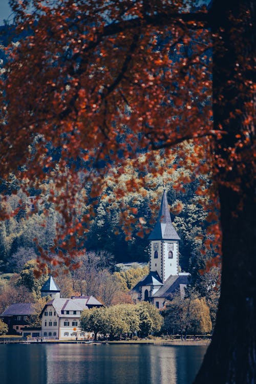 A church in the fall with trees and water