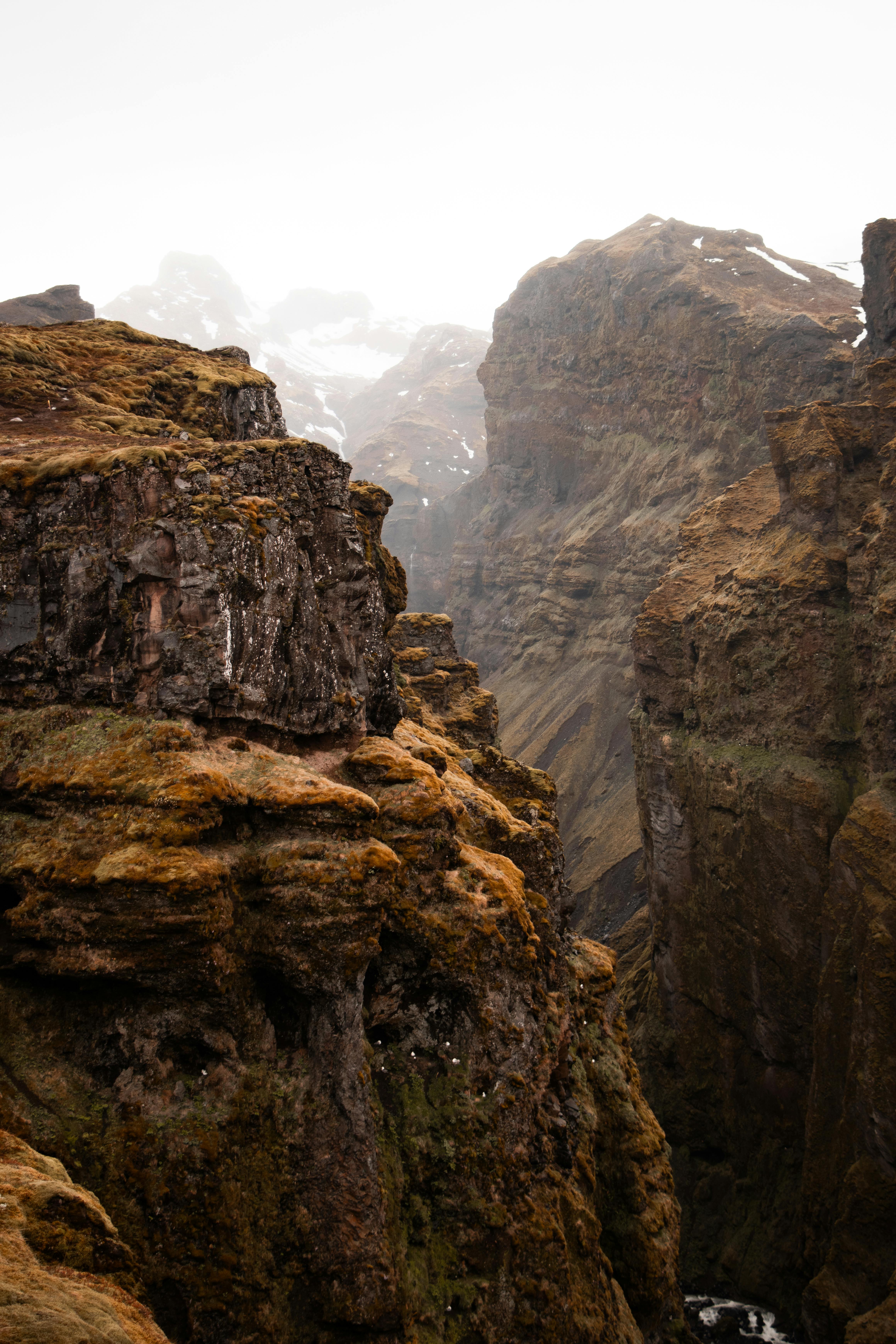 A breathtaking view of a rugged mountain gorge enveloped in mist, showcasing nature's raw beauty.