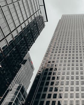 Low angle view of modern skyscrapers in London's financial district, showcasing futuristic architecture.