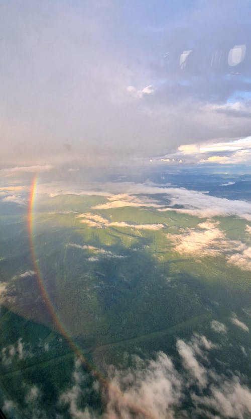 A rainbow is seen from an airplane window