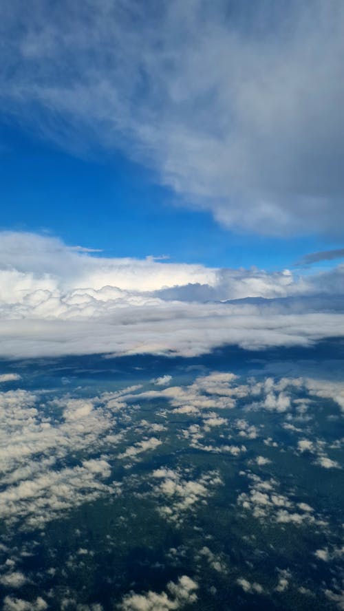 A view from an airplane window of clouds and blue sky