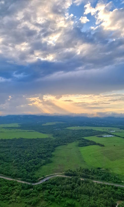 A view of the sky and green fields from above