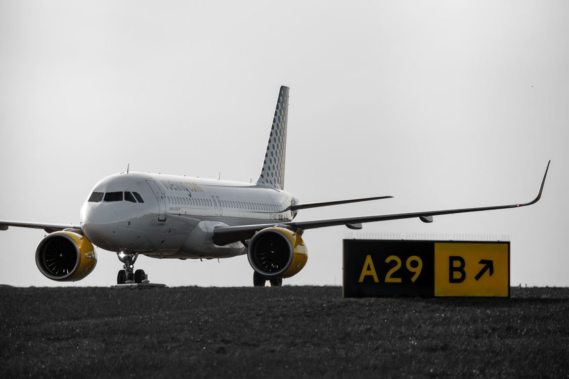 Passenger airplane taxiing on an airport tarmac near the terminal
